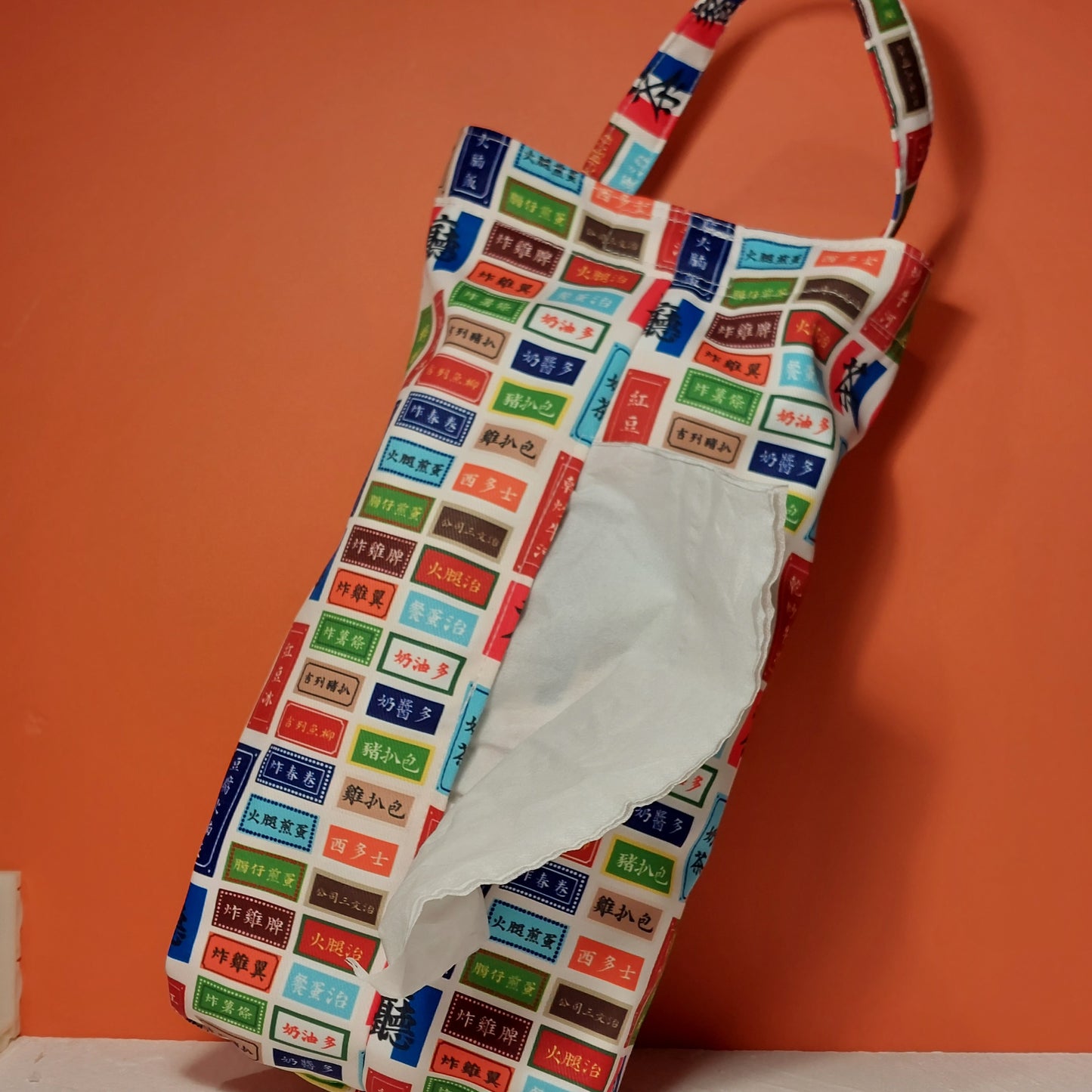 Handmade fabric tissue dispenser bag featuring a colorful retro Hong Kong cafe menu pattern