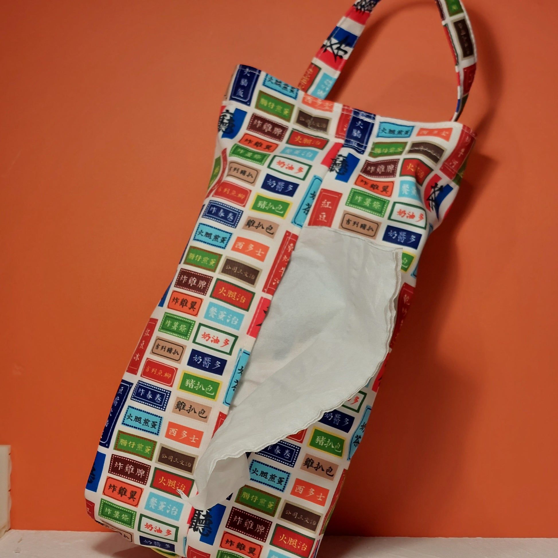 Handmade fabric tissue dispenser bag featuring a colorful retro Hong Kong cafe menu pattern
